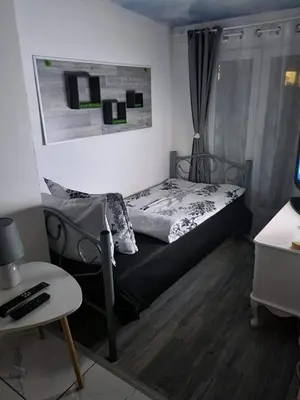 a small bedroom with a bed and a table at Libera in Sofia