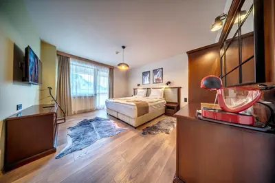 a bedroom with a bed and a desk and a television at Mountain Lake Hotel in Smolyan