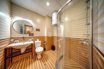 a bathroom with a toilet and a sink and a shower at Mountain Lake Hotel in Smolyan