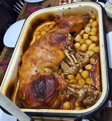a chicken in a pan with potatoes and beans at Vakarel Residence in Vakarel