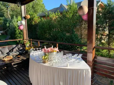 a table with wine glasses and flowers on a patio at Vakarel Residence in Vakarel