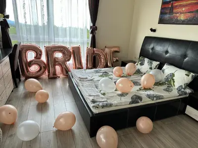 a room with a bed with balloons and the word baptism at Vakarel Residence in Vakarel