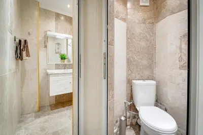 a bathroom with a toilet and a sink and a shower at Unique atmosphere with golden standard design in Sofia