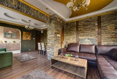 a living room with a leather couch and a brick wall at Unique atmosphere with golden standard design in Sofia