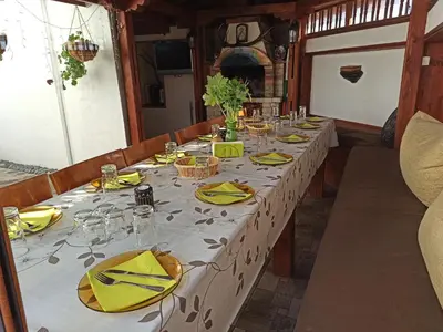 a long table with yellow napkins and glasses on it at Guest House Ganovi in Kalofer