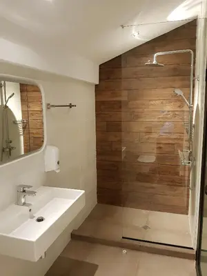 a bathroom with a sink and a glass shower at Mihaylova kushta in Lyubosh