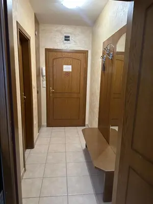 a bathroom with a wooden door and a tile floor at Apartments & Rooms Royal Plaza in Borovets