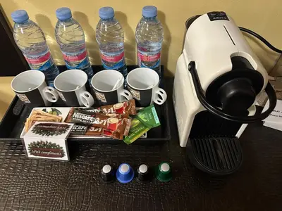 a coffee maker with cups and water bottles on a table at Apartments & Rooms Royal Plaza in Borovets