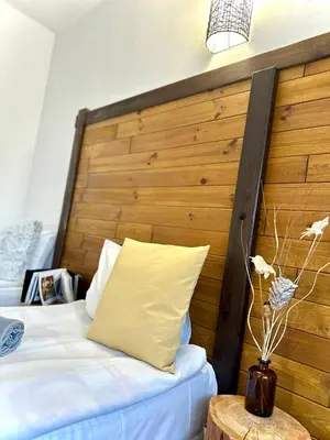 a bedroom with a bed with a wooden headboard at Red House Family house in Bansko