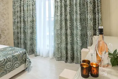 a bedroom with a bed and a table with wine glasses at Hotel Capri in Plovdiv