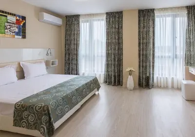 a hotel room with a bed and a large window at Hotel Capri in Plovdiv