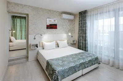 a hotel room with a bed and a window at Hotel Capri in Plovdiv