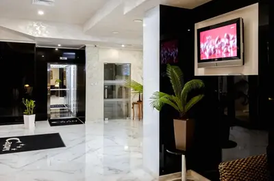 a lobby with a tv on a wall and a plant at Hotel Capri in Plovdiv