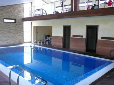 a large swimming pool with blue water in a building at Lux Studio 45 in Fortuna in Bansko
