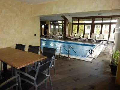 a pool with chairs and a table and a wooden floor at Lux Studio 45 in Fortuna in Bansko