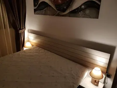 a bedroom with a bed with two lights next to it at Lux Studio 45 in Fortuna in Bansko