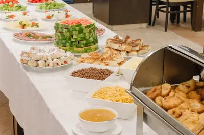 a buffet of food on a white table at Eco Hotel Zdravetz in Tsar Kaloyan