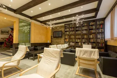 a library with white chairs and bookshelves at Eco Hotel Zdravetz in Tsar Kaloyan