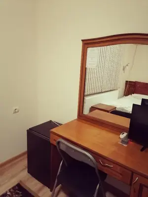 a bedroom with a desk with a mirror and a bed at Guest House Nani in Asenovgrad