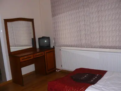 a bedroom with a mirror and a bed and a television at Guest House Nani in Asenovgrad