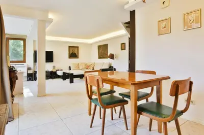 a dining room and living room with a table and chairs at Portofino Apartment in Sofia