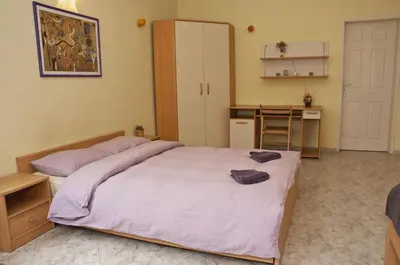 a bedroom with a large bed and a kitchen at Hostel Mostel Sofia in Sofia