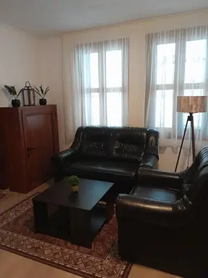 a living room with a black leather couch and a coffee table at Mario Complex in Melnik