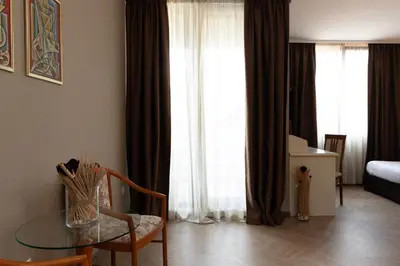 a living room with a glass table in front of a window at St. George Hotel in Sofia