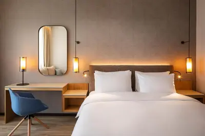 a bedroom with a bed and a chair and a mirror at Hyatt Regency Pravets Resort in Pravets