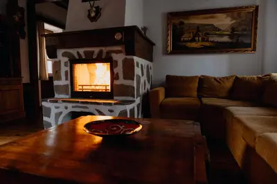 a living room with a fireplace and a table at Chalet White Fang in Bansko