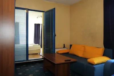 a living room with a blue couch and a table at Fenix Family Hotel in Blagoevgrad