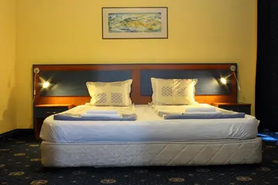 a bedroom with two beds with white sheets and pillows at Fenix Family Hotel in Blagoevgrad