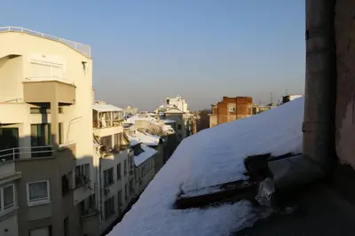 a snow covered roof in a city with buildings at Studio 5 Corners in Sofia