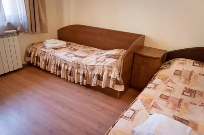 a small bedroom with a bed and a dresser in it at Medic Hotel in Sofia