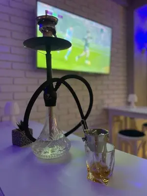 a table with a lamp and two glasses on it at The Secret Garden in Ognyanovo