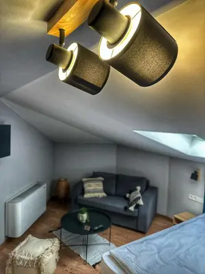 a living room with a couch and two lights on the ceiling at The Secret Garden in Ognyanovo