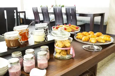 a table topped with jars of food and pastries at City Avenue Hotel in Sofia
