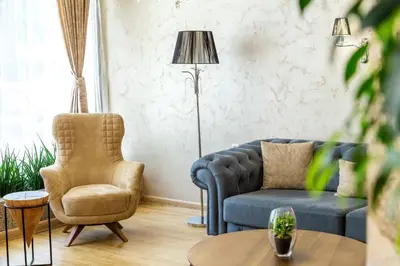 a living room with a blue couch and a chair at City Avenue Hotel in Sofia