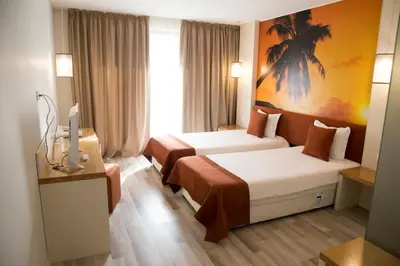 a hotel room with two beds and a television at Tsarsko Selo Spa Hotel in Sofia