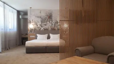 a bedroom with a bed and a couch and a chair at Tsarsko Selo Spa Hotel in Sofia