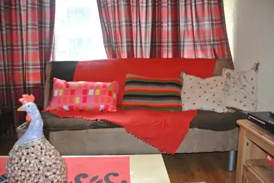 a couch with pillows and a chicken in a room at Feels like Home 