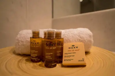 three bottles of honey on a wooden table with towels at Borovets Chalets in Borovets