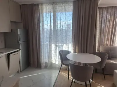 a kitchen with a table and chairs and a window at Apartments Mladost 1A in Sofia