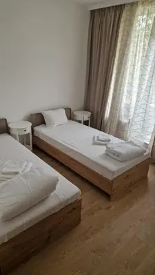 two twin beds in a room with a window at Apartments Mladost 1A in Sofia