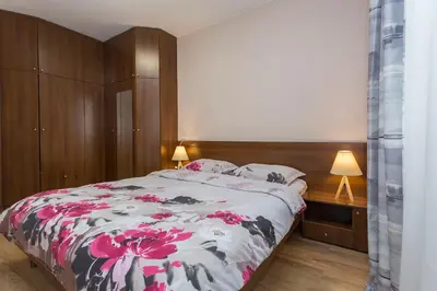 a bedroom with a large bed with pink flowers on it at Sofia Central Hotel Apartments in Sofia