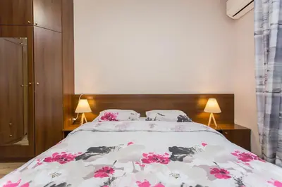 a bedroom with a bed with pink flowers on it at Sofia Central Hotel Apartments in Sofia