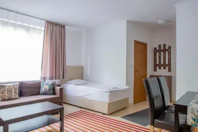 a bedroom with a bed and a couch and a table at Apartments in Complex Grand Manastira in Pamporovo