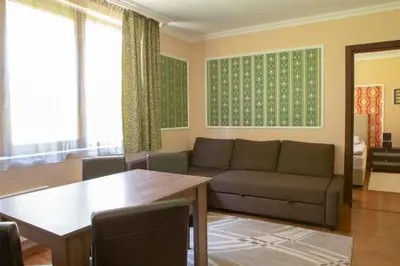 a living room with a couch and a table at Apartments in Complex Grand Manastira in Pamporovo