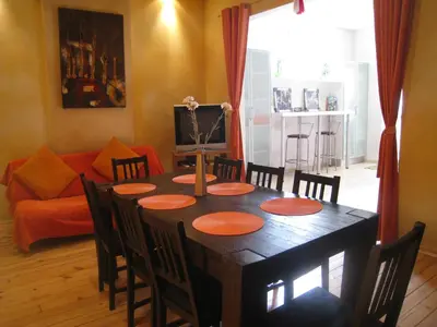 a dining room with a table with chairs and a couch at Elegance on a Budget - Rooms for Rent in Sofia Center in Sofia