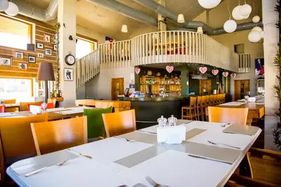 a restaurant with tables and chairs and a bar at White Lavina - Ski, Bike, Hike in Bansko
